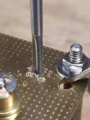 Tapping a clock movement plate to take a screw